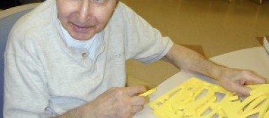 Martin Avadian trying to solve a puzzle in the activity room of a nursing home.