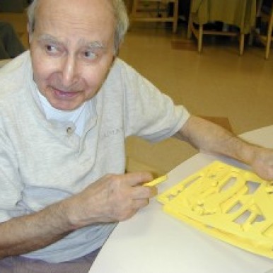 Martin Avadian trying to solve a puzzle in the activity room of a nursing home.