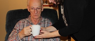 Caregiver Sheri Zschocher helping husband Bob with coffee