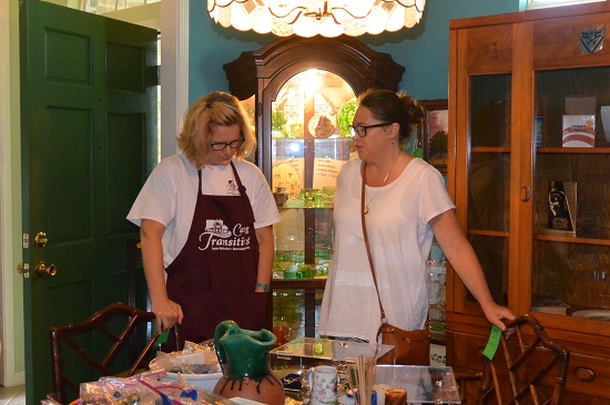 Caring Transitions owner consults with estate sale shopper on value of items