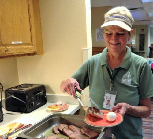 Long-time nutritional aide, Betty at Bell Tower Residence Serving Protein Rich Breakfast