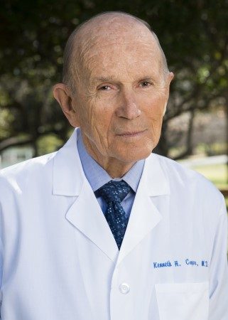 Outdoor close-up image of Dr. Cooper in white lab coat bearing his name