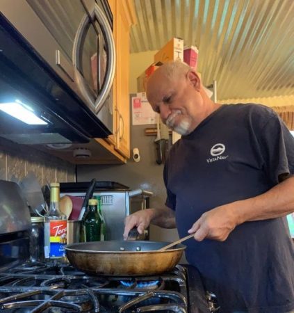 Caregiver Bruce Williams cooking at the stove