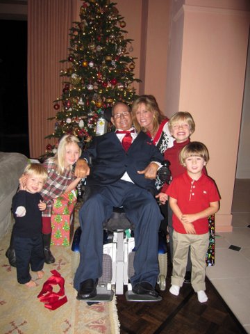 The Kolls - Don and Kathi with four grandkids in front of a Christmas Tree