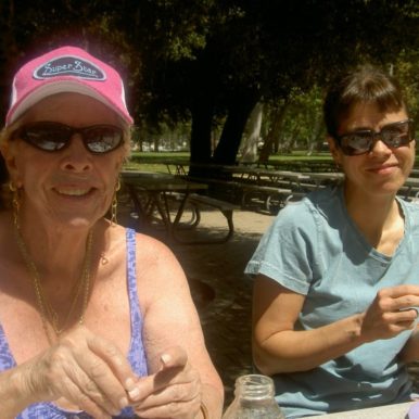 Caregiver companion w elder picnic table eating pistachios Tori Tellem inspiration