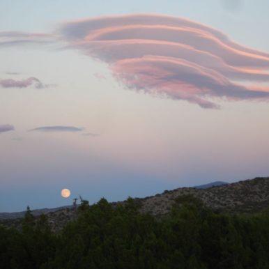 Image of full moon rising at horizon with dramatic lenticular clouds. Avadian photo 2012