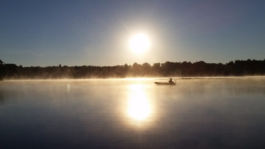 Lone boater on Stone Lake in Wisconsin at sunrise