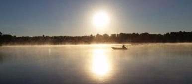 Lone boater on Stone Lake in Wisconsin at sunrise