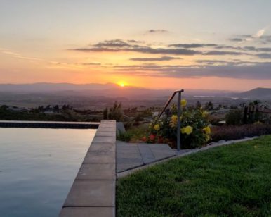 View of infinity pool and gardens at sunset for self-care