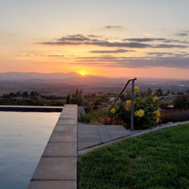 View of infinity pool and gardens at sunset for self-care
