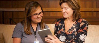 Assurance-Home-Care-Two-ladies-smiling-looking-at-Tablet