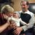 Author, Julie Bennett shares smiles with grandbaby sitting on her husband's lap