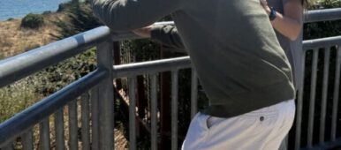 Melissa Mirabello smiling at an older man looking out to the sea below - TCV